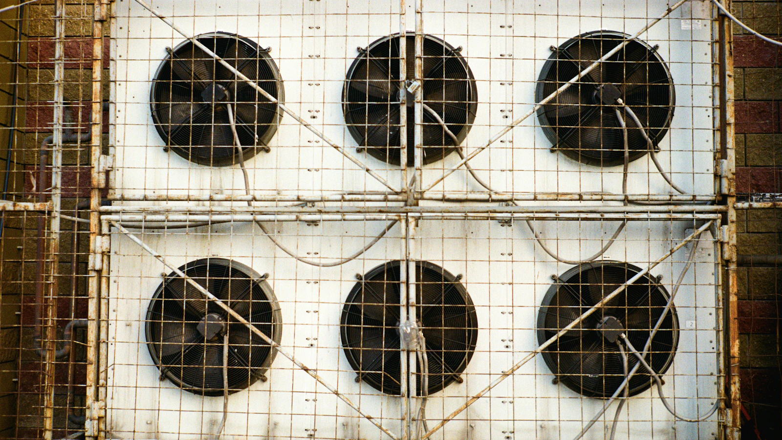 Six industrial cooling fans mounted behind protective metal grilles