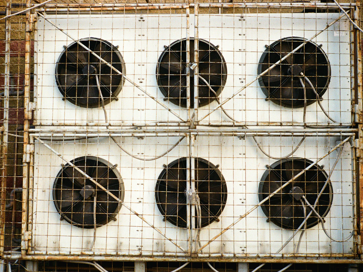 Six industrial cooling fans mounted behind protective metal grilles