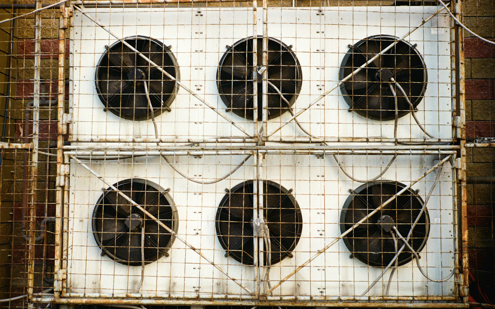 Six industrial cooling fans mounted behind protective metal grilles